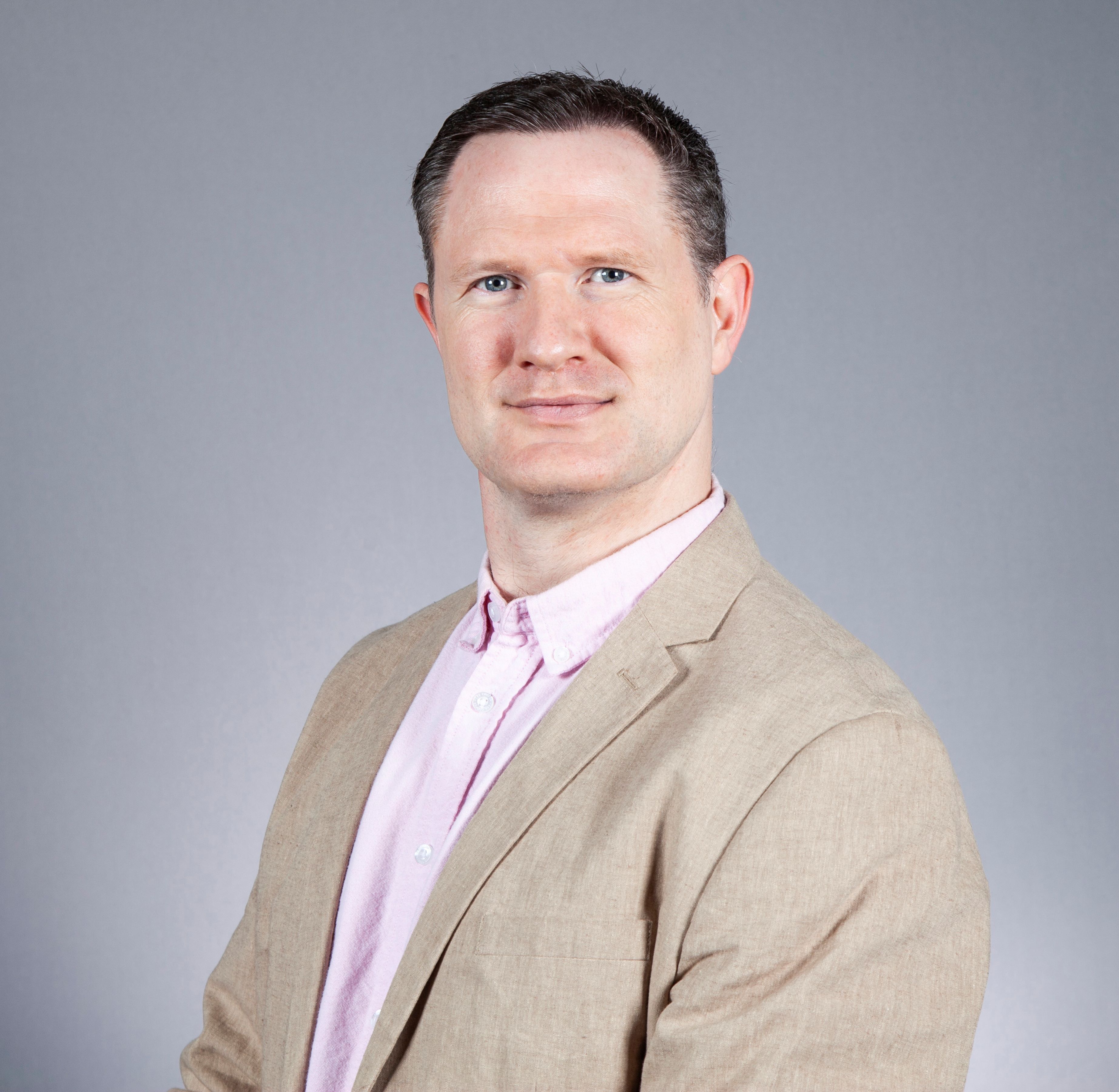 Paul Fannon headshot wearing beige jacket and shirt