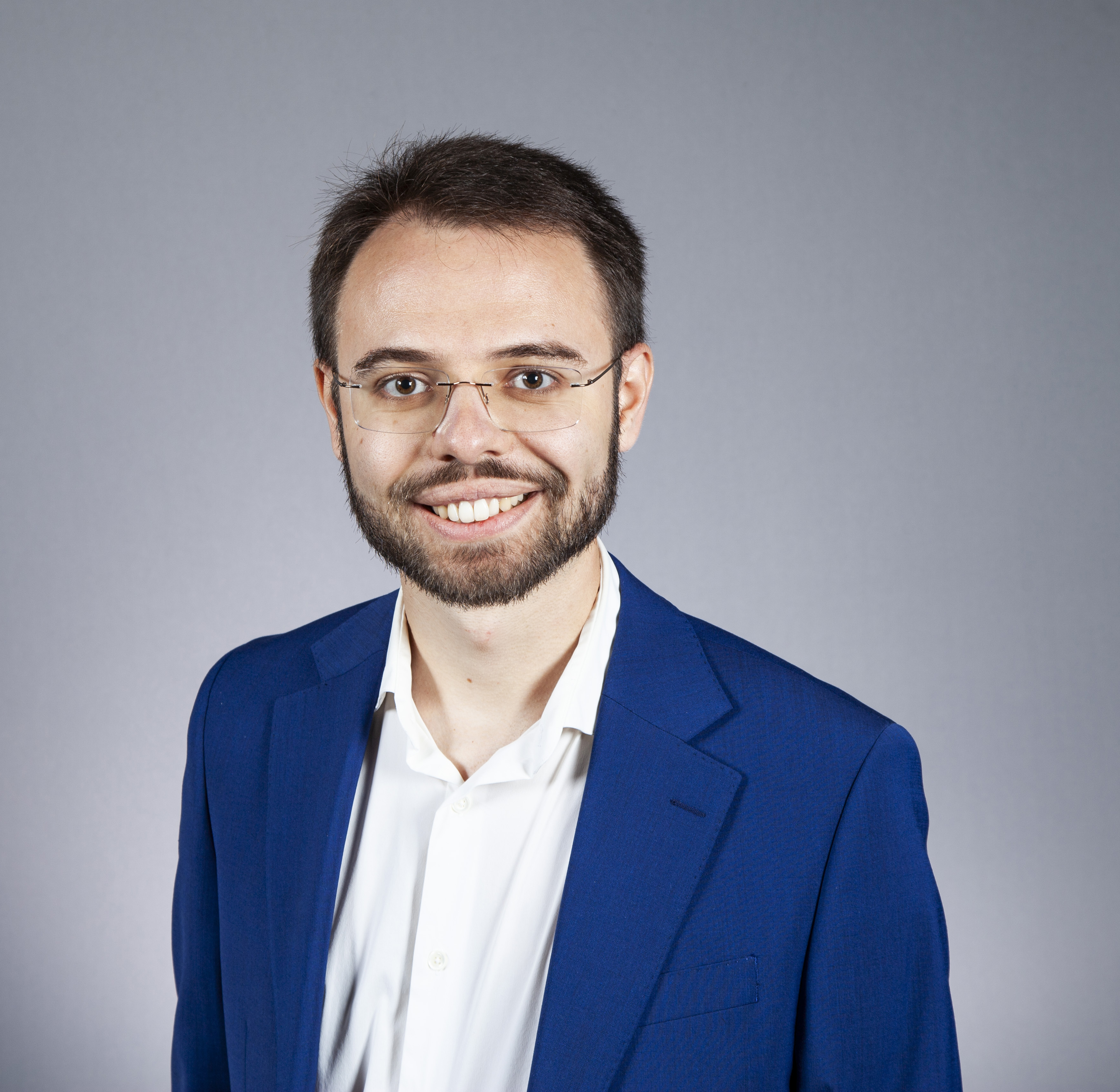 Smiling person with a beard and glasses