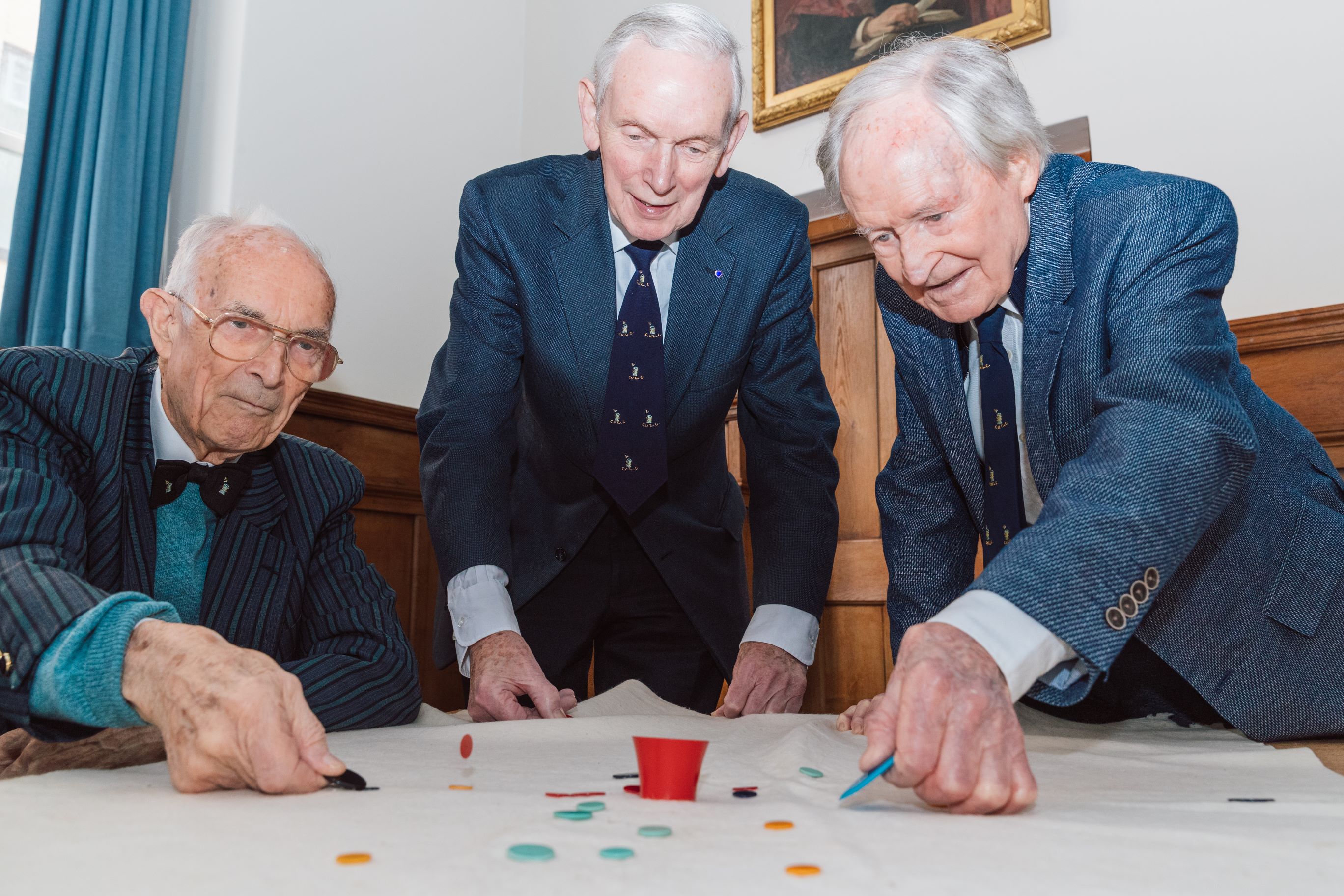 Three people playing tiddlywinks