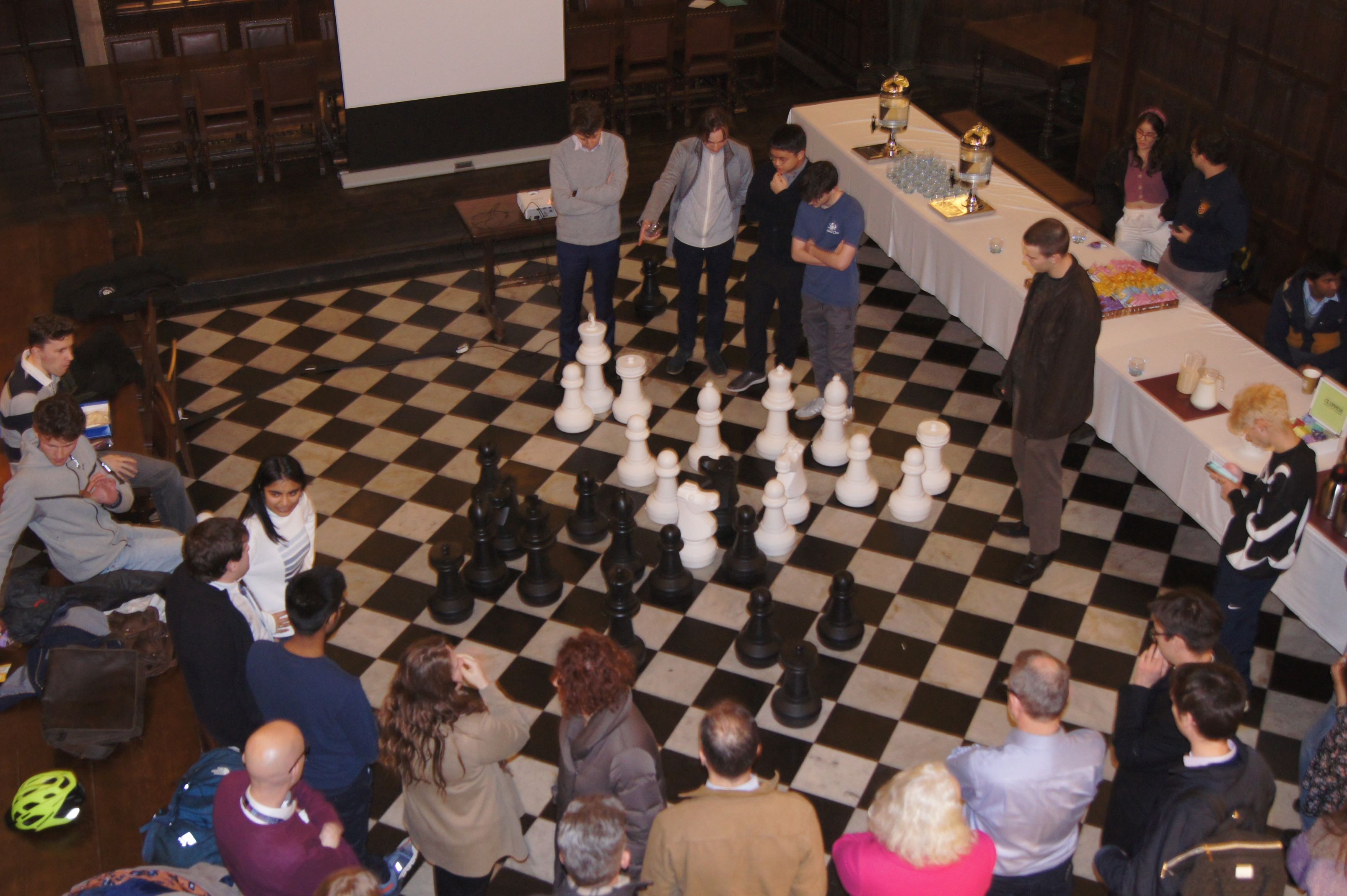 People gathered around a large chess set