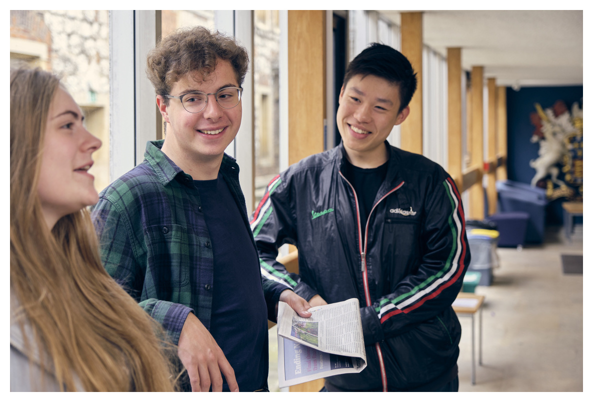 Three students talking in the Library foyer, Christ's College, Cambridge