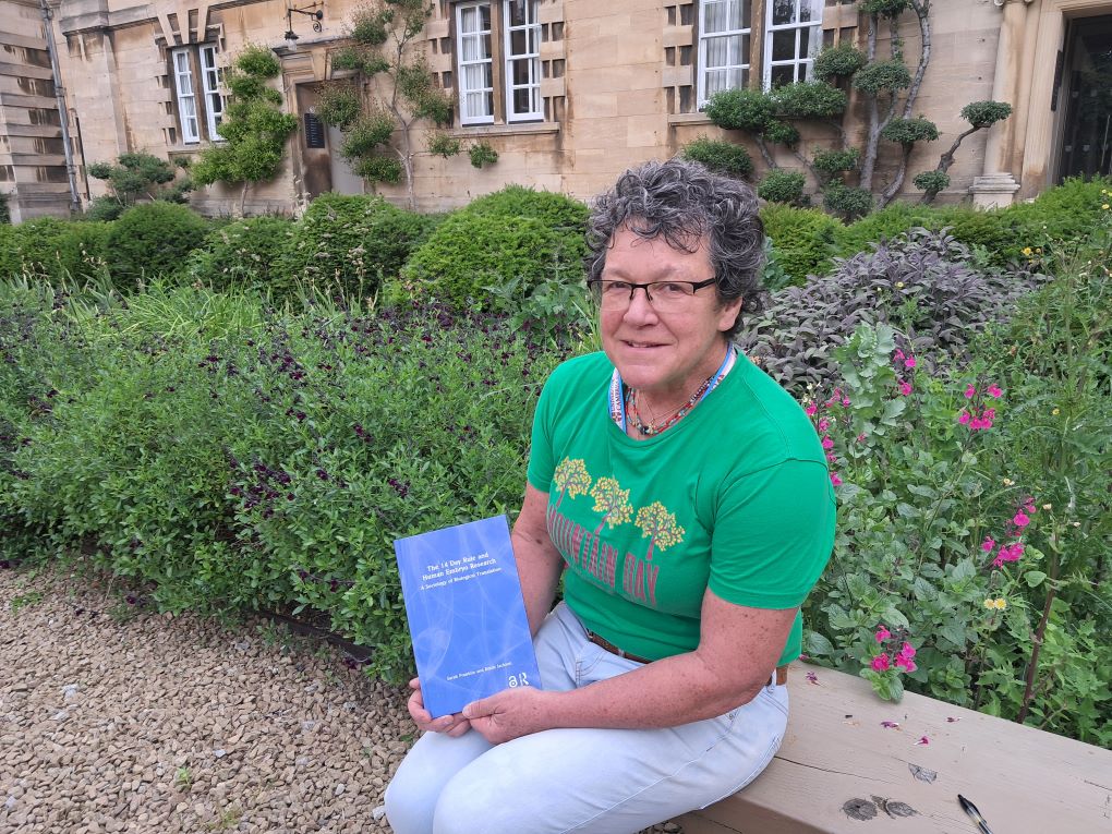 Person sitting on a bench holding a book