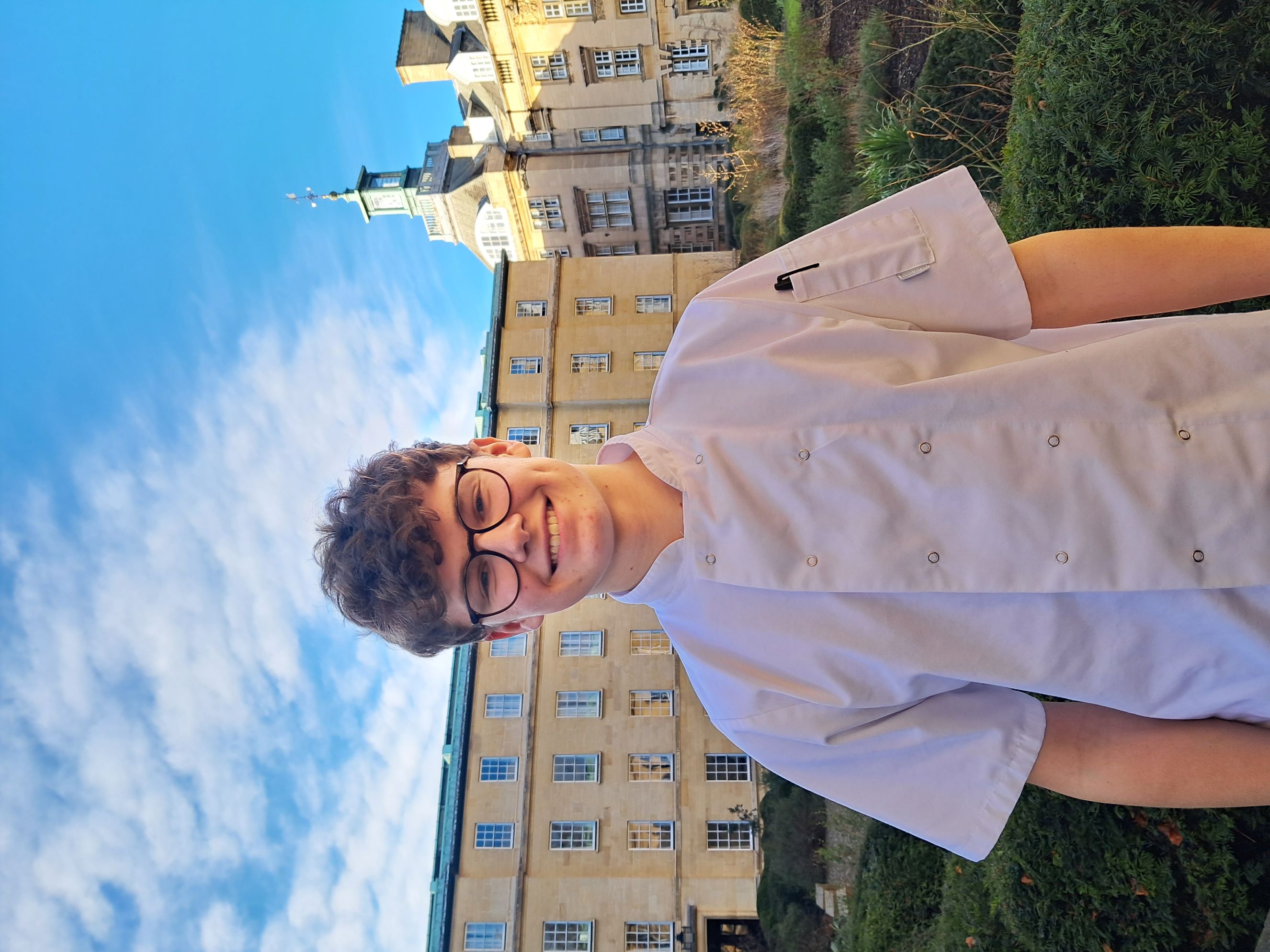 Smiling person in chef uniform and glasses