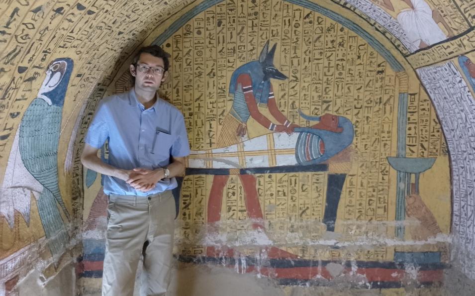 Alex Loktionov standing in front of hieroglyphs