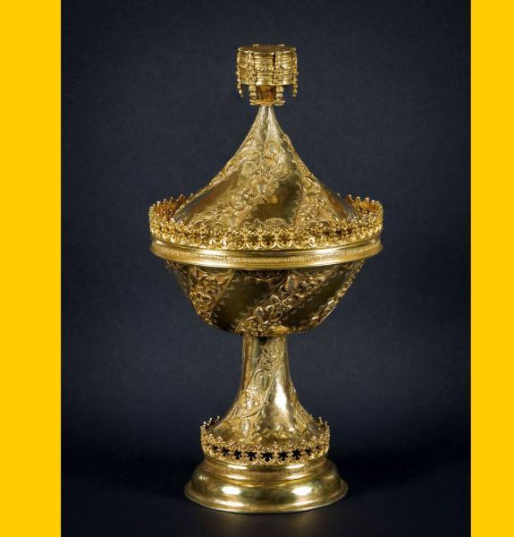 Ornate gilt cup against dark background