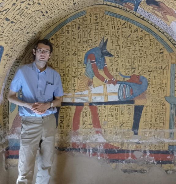 Alex Loktionov standing in front of hieroglyphs