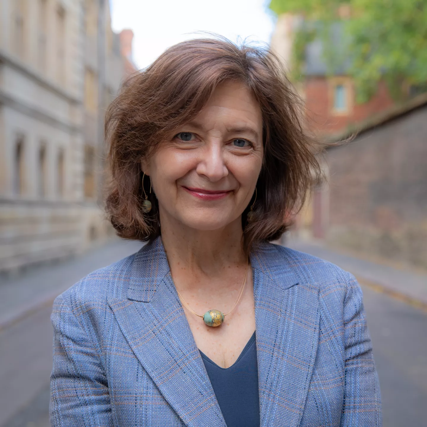 Person wearing blue jacket, top and necklace