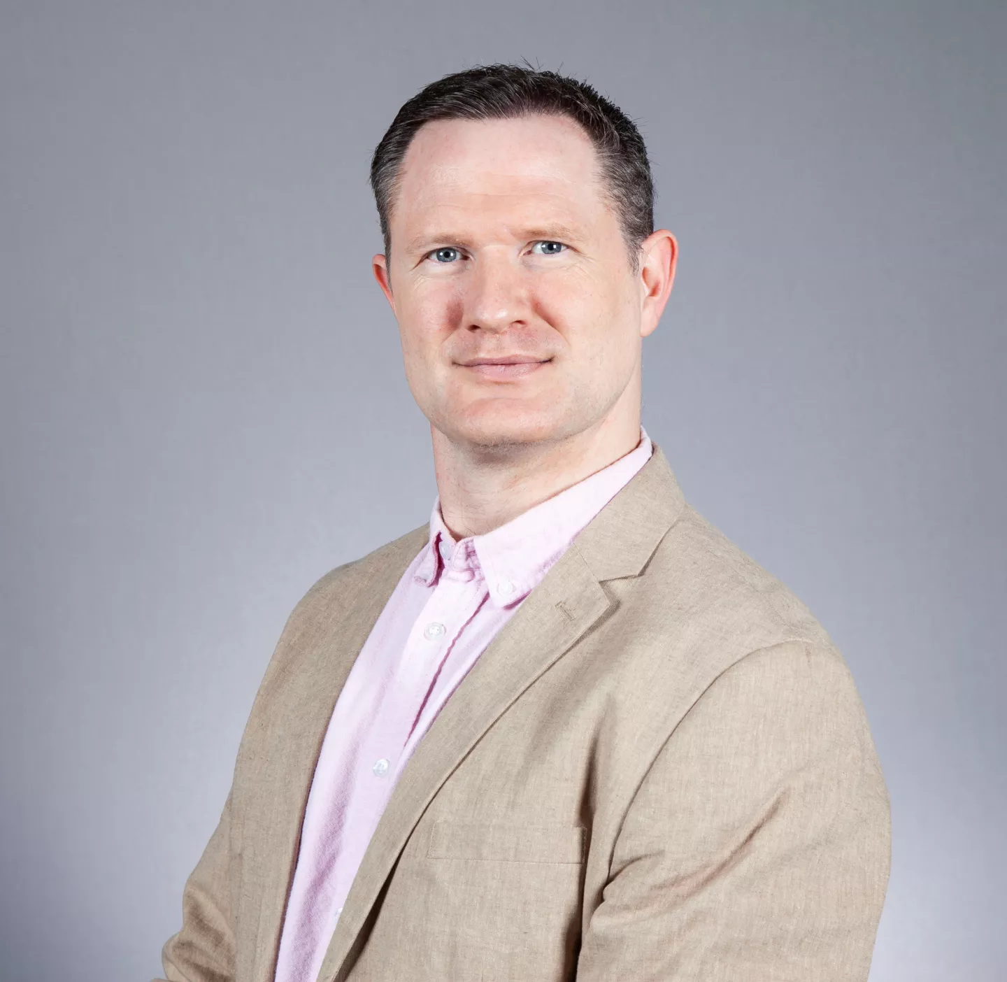 Paul Fannon headshot wearing beige jacket and shirt