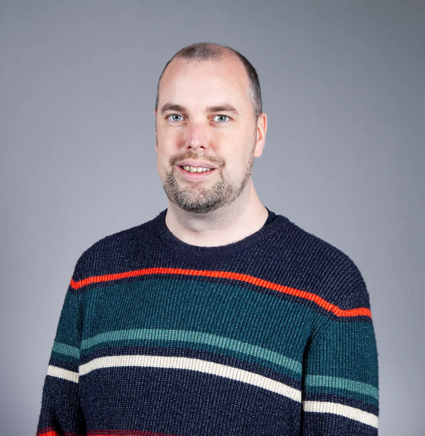 Mike Housden headshot wearing striped jumper