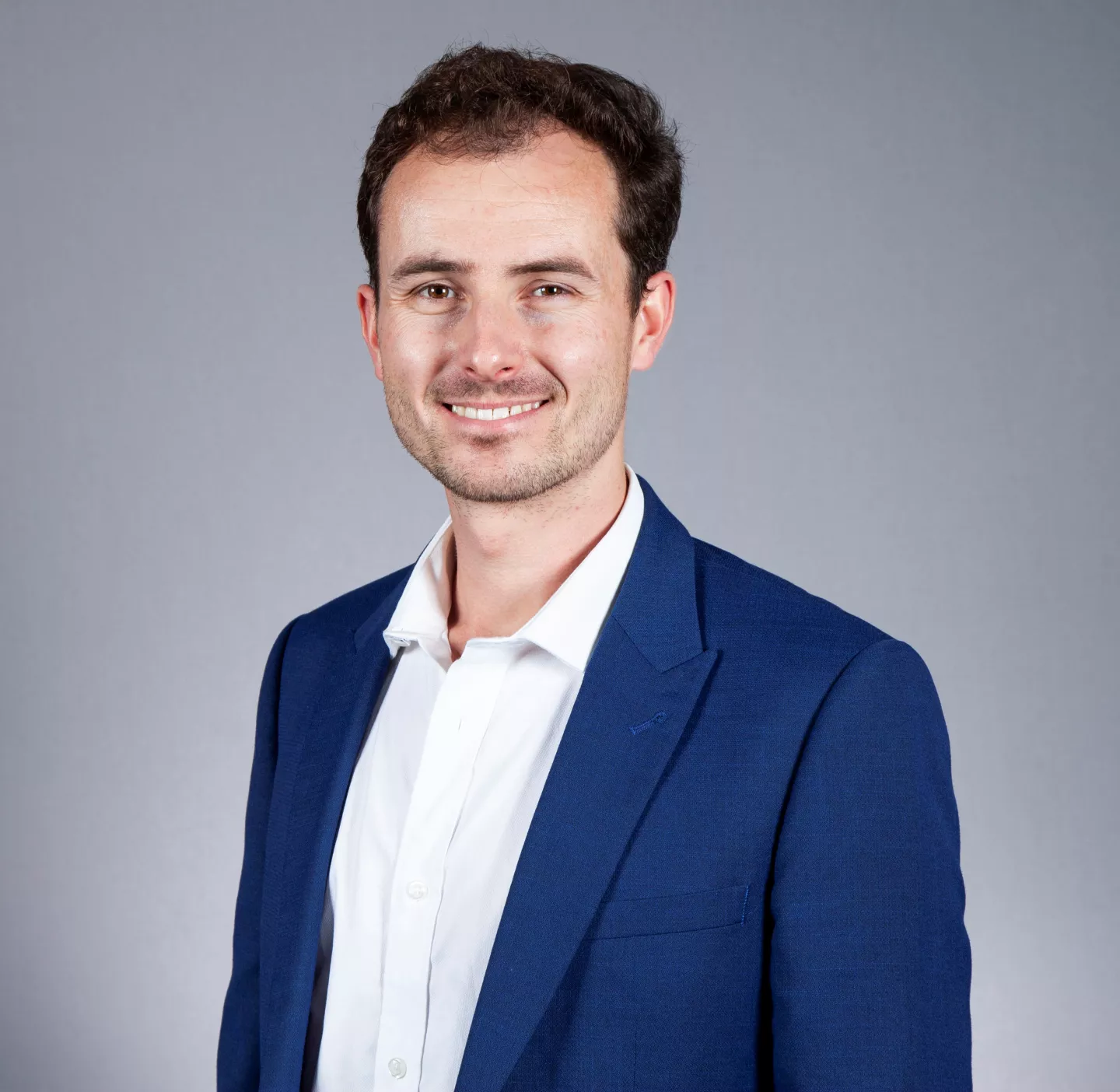 Miles Kempton headshot wearing a blue jacket