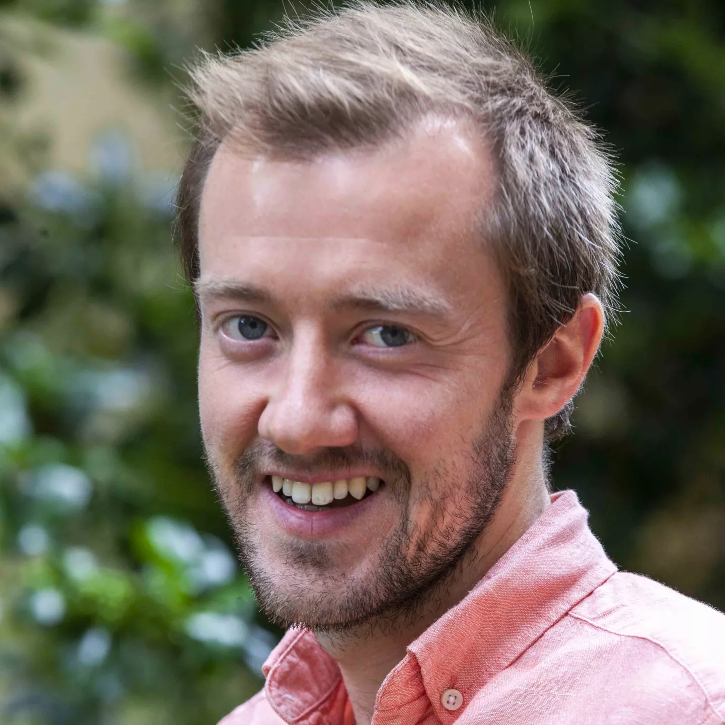 Smiling person in pink shirt