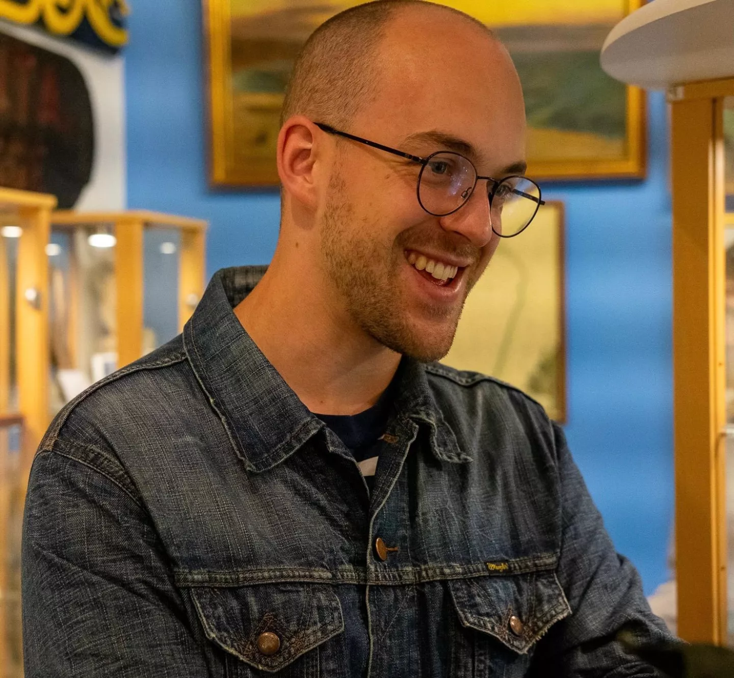 Headshot of William Freeman wearing a denim jacket and glasses